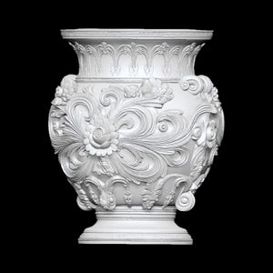 Pu&ograve; includere: Un vaso bianco e ornato con intricati disegni floreali e a volute. Il vaso presenta un bordo ampio e dettagliato e una base a piedistallo. Il design generale &egrave; simmetrico e classico, con un focus sulla consistenza e il rilievo.