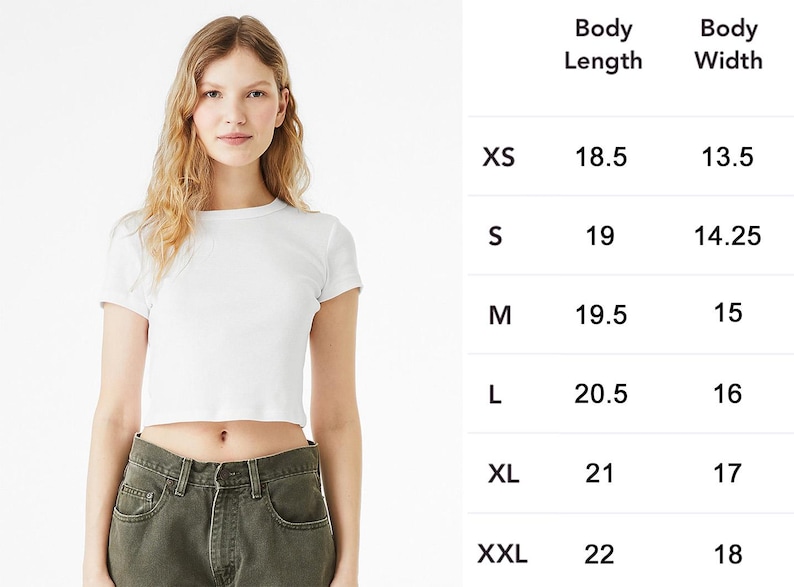 May include: A white, short-sleeved crop top. The image includes a size chart with body length and width measurements in inches for sizes XS to XXL. The model is wearing the crop top with olive green pants.