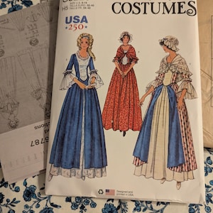 Può includere: Cartamodello Simplicity Costumi S3226 con illustrazioni di abiti storici. Il modello include taglie 32-40. La copertina mostra tre donne in abiti d'epoca, con uno sfondo floreale blu e bianco.