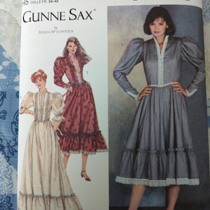 May include: Simplicity Gunne Sax sewing pattern, size U.S. 6-14. The pattern features illustrations of vintage dresses with long sleeves, ruffled hems, and lace trim. The cover includes the text "GUNNE SAX" and "Simplicity".