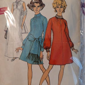 May include: Vintage Simplicity sewing pattern with illustrations of three dress designs. The designs include a white maxi dress, a blue mini dress with a fringed sash, and a red mini dress. The pattern includes sizing information: Size 18, Bust 40.