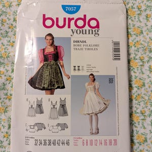 May include: A sewing pattern for a dirndl dress, with instructions in English, French, German, and Spanish. The pattern includes sizes 32 to 46 and 6 to 20. The pattern is for a traditional dirndl dress with a bodice, skirt, and apron.