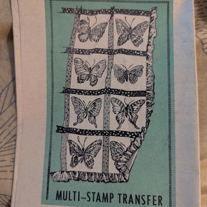 May include: A vintage multi-stamp transfer sheet featuring eight butterfly designs in black and white. The butterflies are arranged in a grid on a teal background, with the text "MULTI-STAMP TRANSFER" and "DESIGN 922" below.