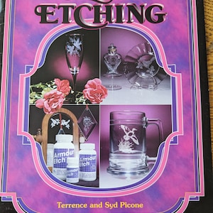 May include: A book cover with a pink and purple background featuring the title "Creative Glass Etching" with a picture of etched glass items, including a wine glass, a heart-shaped bottle, a plate, a mug, and bottles of etching solution.