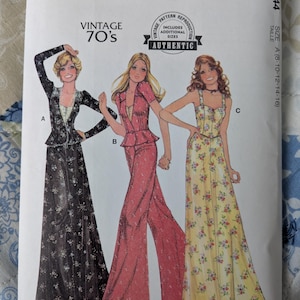 May include: A vintage McCall's sewing pattern from the 1970s, featuring illustrations of three different outfits. The pattern includes a long black floral dress, a pink pantsuit, and a yellow floral dress. The pattern size is A (8-10-12-14-16).