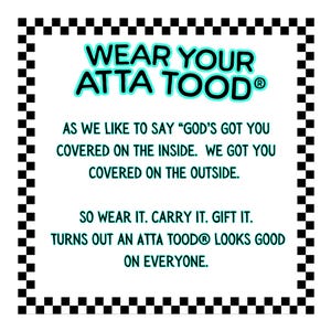 May include: White rectangular sign with a black and white checkered border. The text "WEAR YOUR ATTA TOOD" is in turquoise, with additional text below. The sign encourages the reader to wear, carry, and gift the product.