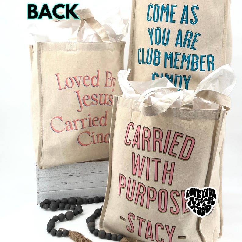 May include: Three canvas tote bags with various phrases printed on them. One says "Loved By Jesus Carried Cindy", another reads "Come As You Are Club Member Cindy", and the third says "Carried With Purpose - Stacy".