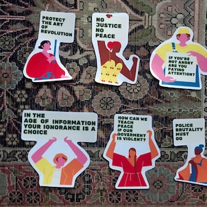 Pu&ograve; includere: Un set di 8 adesivi colorati con illustrazioni di persone che tengono cartelli con messaggi su giustizia sociale, pace e governo. I cartelli hanno testo in verde, e le illustrazioni sono di vari colori, tra cui rosso, giallo, blu e rosa.