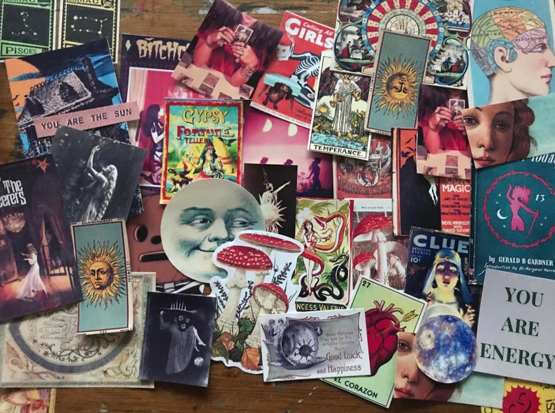 May include: A collection of vintage and modern stickers featuring various designs, including a moon face, mushrooms, a heart, a sun, a snake, a woman, and a tarot card. The stickers are on a wooden surface.