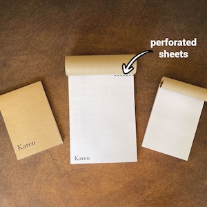 Puede incluir: Dos cuadernos de papel marrón con el nombre "Karen" impreso en la portada. El cuaderno de la derecha tiene hojas perforadas.