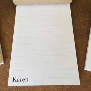 K&ouml;nnte beinhalten: Ein wei&szlig;er, linierter Notizblock mit dem Namen "Karen" am unteren Rand.