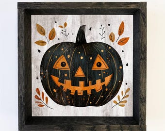 May include: A framed Halloween artwork. It features a black pumpkin with orange facial features and a smiling mouth. The pumpkin is set against a light grey background with autumn leaves and a dark wooden frame. A festive decoration.