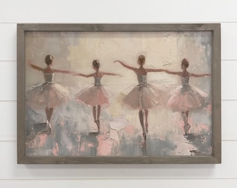 May include: A framed painting shows four ballerinas in soft pink tutus and white tops, arms outstretched. The artwork uses a palette of pink, grey, and cream, with visible brushstrokes. The frame is a muted grey, enhancing the painting's delicate aesthetic.