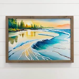 May include: Watercolor painting of a beach scene with a sunset. The artwork features a wooden frame, a sandy shore, and waves in shades of blue and turquoise. The sky transitions from yellow to orange, with trees and mountains in the background.