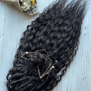 May include: A long, dark brown, curly hair extension with two gold chains and pearl accents.
