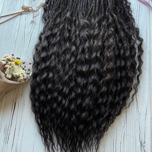 May include: A set of long, dark brown curly dreadlocks. The dreadlocks are arranged in a loose, flowing style.