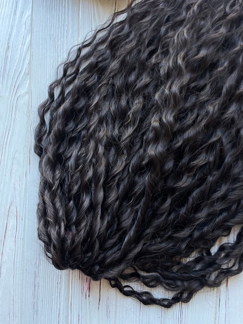 May include: A bundle of dark brown curly hair extensions.