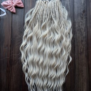 May include: A set of long, wavy, white synthetic dreadlocks. The dreadlocks are arranged in a straight line and are hanging down.