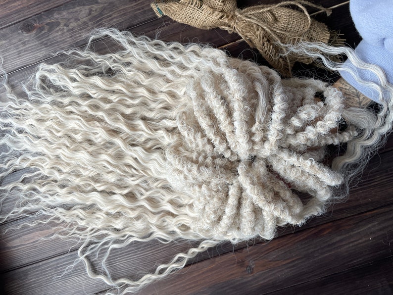May include: A long, white, curly wig with a thick, textured braid. The wig is made of synthetic fibers and is perfect for adding volume and length to your hair.