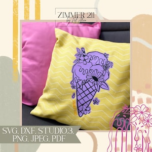 Op de afbeelding: Een geel kussen met een zwart en paars ijshoorntje ontwerp met bloemen. De tekst "SUMMER VIBES" staat op het hoorntje. Het kussen ligt op een roze kussen.