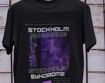 Könnte beinhalten: Schwarzes T-Shirt mit einem grafischen Design mit einem violetten und weißen abstrakten Design und dem Text "Stockholm Syndrome".