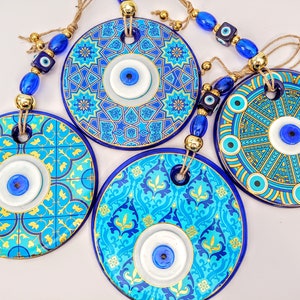 May include: Four blue and gold round ceramic wall hangings with evil eye charms. Each hanging features a different blue and gold geometric pattern.