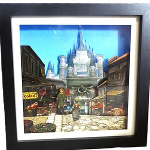 Op de afbeelding: Een ingelijst 3D-kunstwerk dat een gedetailleerde scène uit een videogame toont. Het kunstwerk toont een kasteel, gebouwen en personages in een stadsomgeving. De lijst is zwart en de achtergrond is een blauwe lucht.