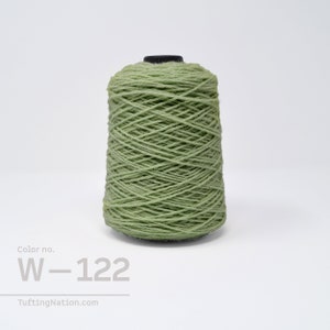 Könnte beinhalten: Eine Spule mit hellgrünem Garn, beschriftet mit "Color no. W-122".