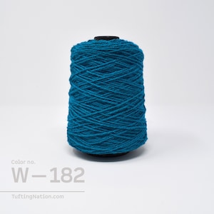 Könnte beinhalten: Ein teal-farbener Garnkegel mit schwarzem Sockel. Das Garn ist eng gewickelt und zeigt eine strukturierte Oberfläche. Der Text "Color no. W-182" ist unten links zu sehen. Die Website "TuftingNation.com" ist ebenfalls sichtbar.