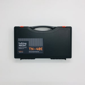 May include: Black hard-shell carrying case with a red latch. The case has a label that says "Tufting Nation. Supplies for Rug Makers tuftingnation.com" and "TN-40E Electric Rug Carving Tool".
