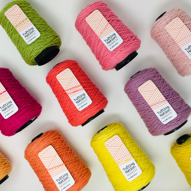 May include: Ten spools of yarn in various colors, including green, pink, red, orange, yellow, and purple. Each spool has a label that reads "Tufting Nation."