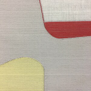 May include: A close-up of a tufted rug with a gray background, a red section, and a yellow section. The rug has a textured, woven appearance.