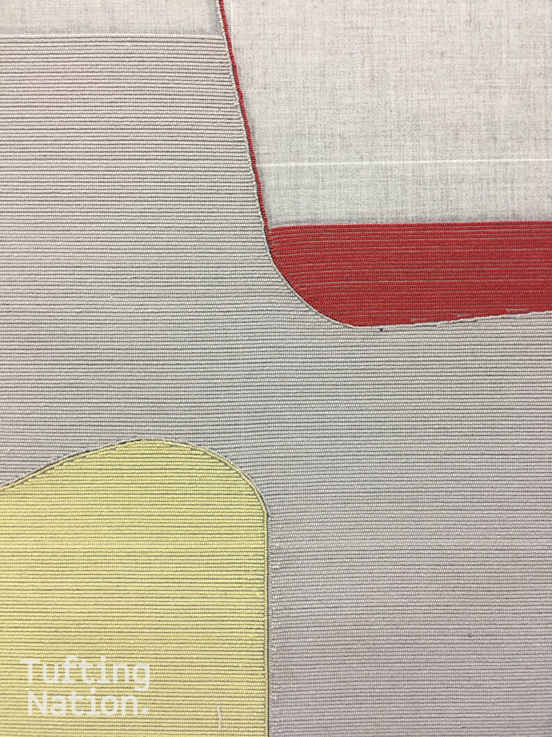 May include: A close-up of a tufted rug with a gray background, a red section, and a yellow section. The rug has a textured, woven appearance.