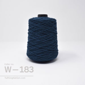 May include: A spool of dark blue yarn, labeled "W-183", for rug hooking or tufting.