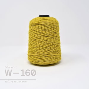 May include: A spool of yellow wool yarn with the color number W-160. The yarn is wound tightly and has a smooth texture.