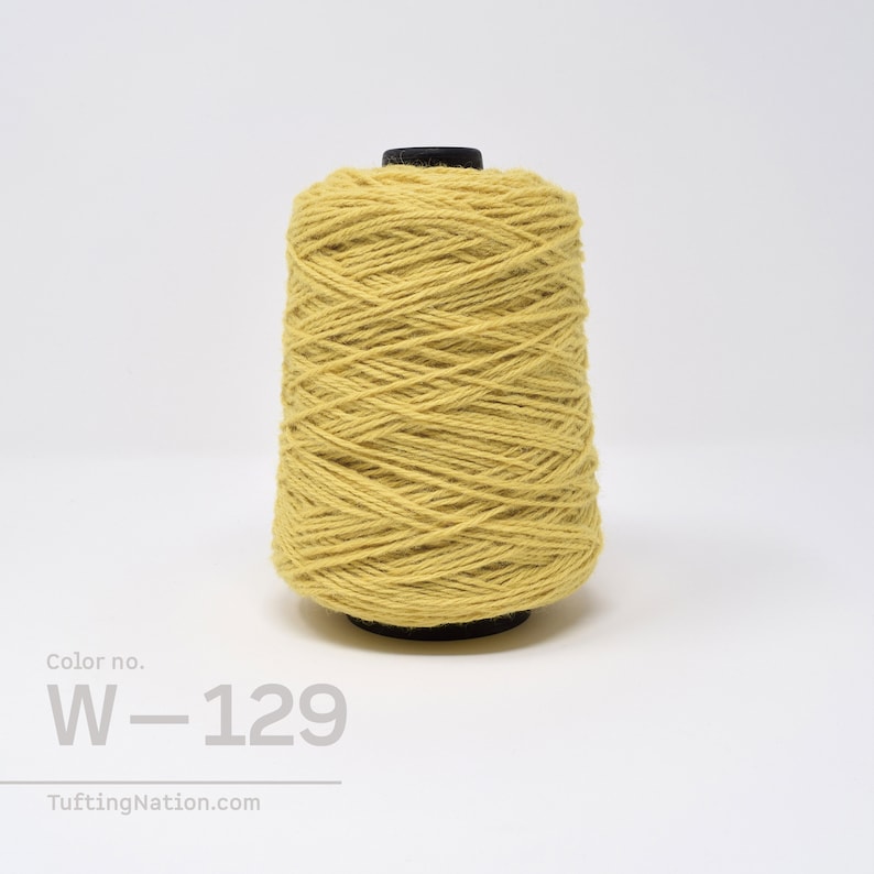 May include: A spool of yellow yarn with the color number W-129. The yarn is wound tightly and is ready for use in crafting projects.