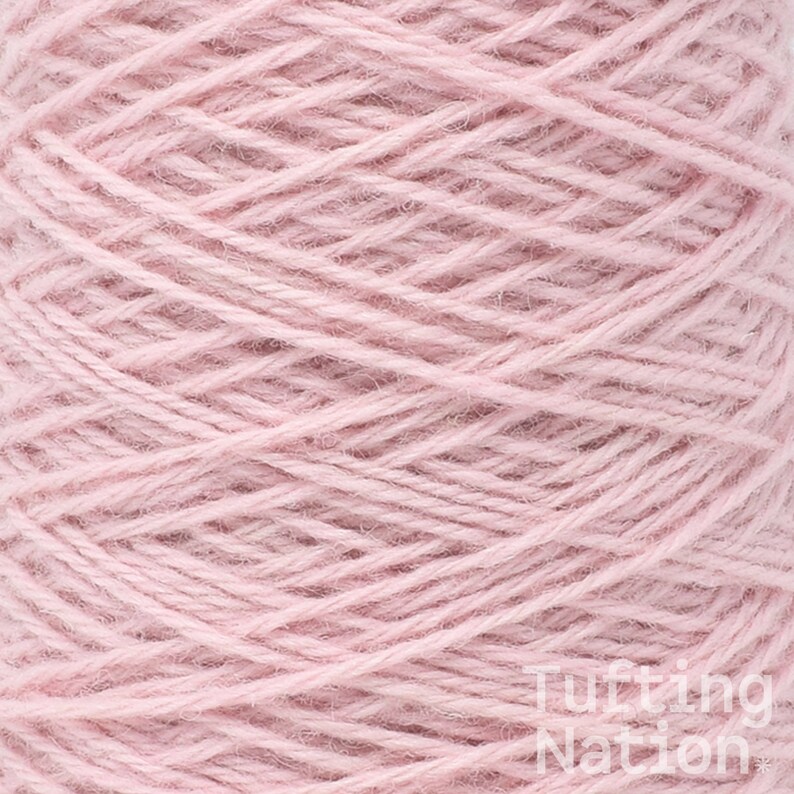 May include: A close-up of a spool of pale pink yarn.