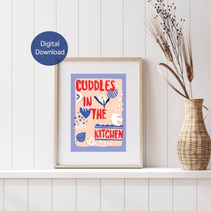 May include: A digital download print with a pink background and blue and white illustrations. The text reads "Cuddles in the Kitchen" in red.