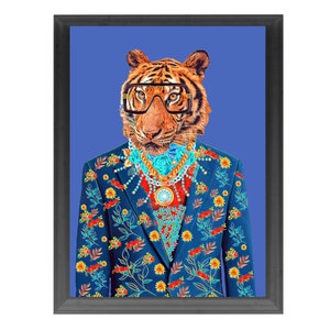 May include: Framed art print of a tiger wearing glasses and a blue suit with a floral pattern. The tiger is adorned with a gold and turquoise necklace and a pendant. The background is a solid blue.