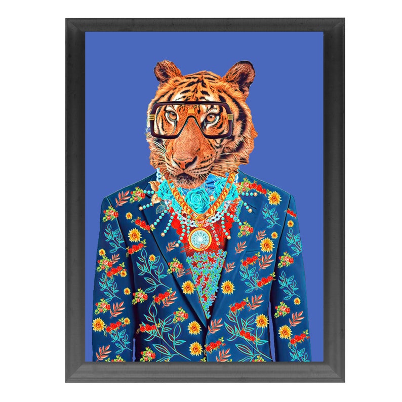 May include: Framed art print of a tiger wearing glasses and a blue suit with a floral pattern. The tiger is adorned with a gold and turquoise necklace and a pendant. The background is a solid blue.