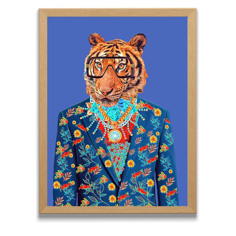 May include: Framed art print of a tiger wearing glasses and a floral suit. The tiger has a gold necklace and a blue suit with red and yellow floral patterns. The background is a solid blue.