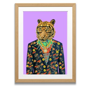 Puede incluir: Impresi&oacute;n art&iacute;stica enmarcada que presenta un tigre con gafas, un traje floral y joyas ornamentadas sobre un fondo p&uacute;rpura. El traje azul marino del tigre tiene un estampado floral colorido. El marco es de color marr&oacute;n claro.