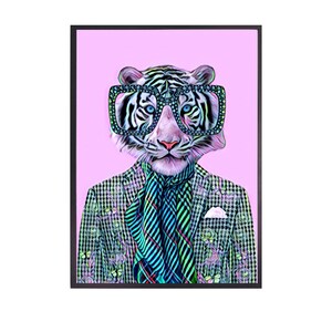 May include: A framed art print featuring a stylized tiger wearing large, square-framed glasses. The tiger is dressed in a patterned blazer, a striped scarf, and a pocket square, set against a pink background. The artwork has a modern, whimsical style.