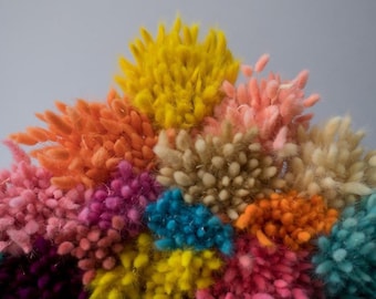 May include: A colourful arrangement of dried flowers in shades of yellow, orange, pink, purple, and teal. The fluffy texture and diverse hues create a visually appealing display, ideal for home decor or crafting projects.