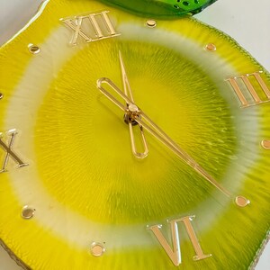 Lemon resin wall clock in detail: gold numbers and gold clock hands