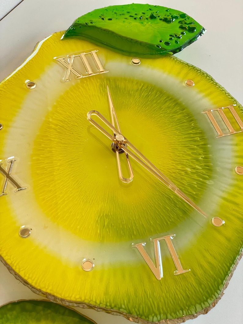Lemon resin wall clock in detail: gold numbers and gold clock hands
