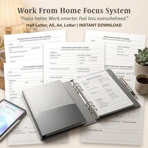 May include: A Work From Home Focus System planner set featuring printed pages with headings like Distraction & Focus Pattern Tracker, Focus Session Tracker, and Work From Home Weekly Reset. A ring binder holds a page, with a pen and tablet nearby.