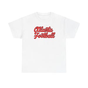 May include: White t-shirt with the words "Atlanta Football" in red script. The text has a retro, cursive style with a shadow effect. The shirt is a casual, everyday wear item.