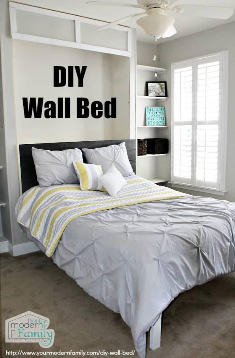 May include: A DIY wall bed with a gray and white striped bedspread and a gray comforter. The bed has a black headboard and is in a bedroom with white walls and a ceiling fan.