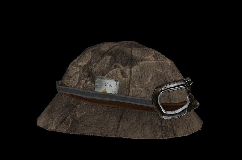 May include: A brown hat with a textured surface, a dark brown band, and a silver buckle. A small, rectangular label with the word "amid" is attached to the hat.